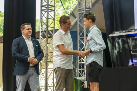Miłosz Krzempek odbiera nagrodę z rąk przewodniczącego